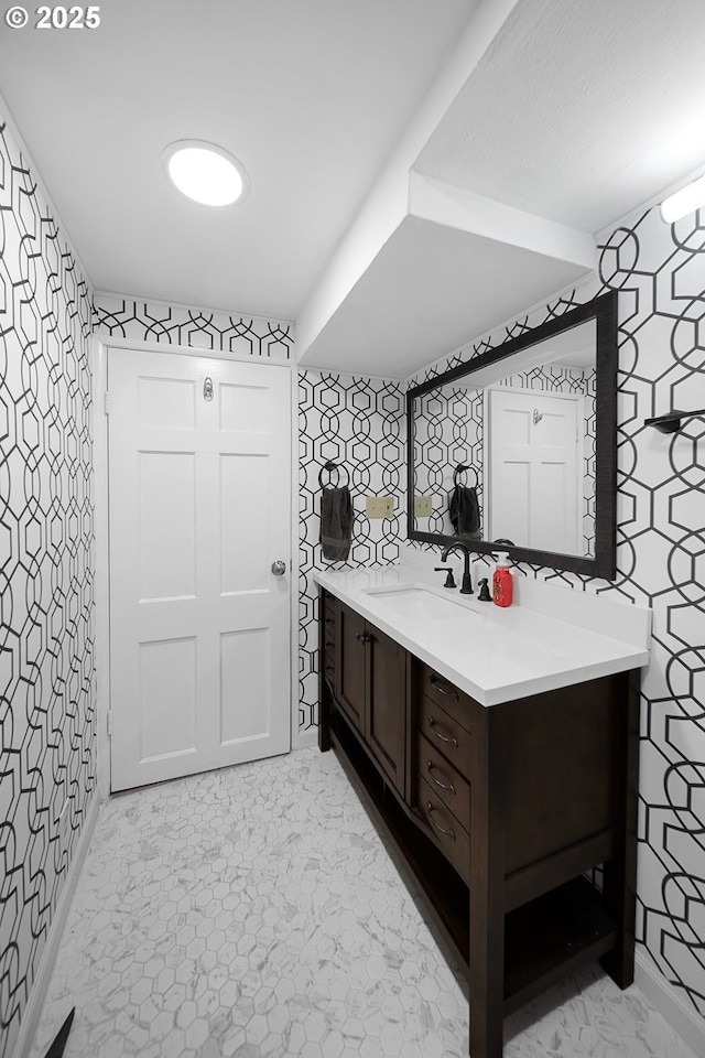 bathroom featuring wallpapered walls and vanity