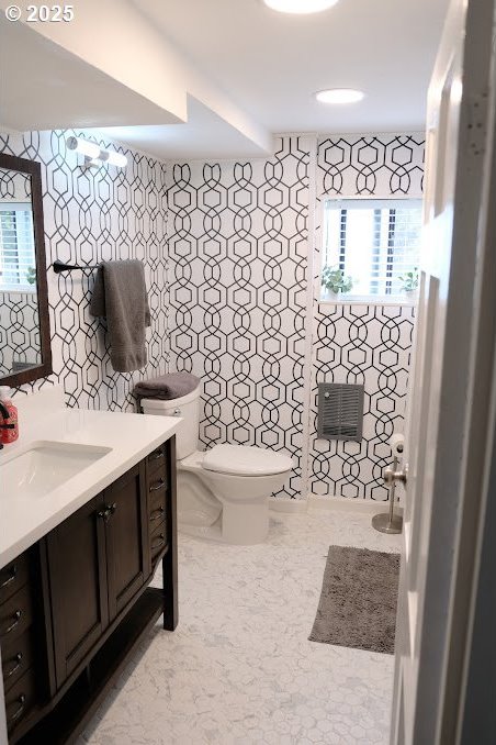 bathroom featuring tile walls, toilet, and vanity