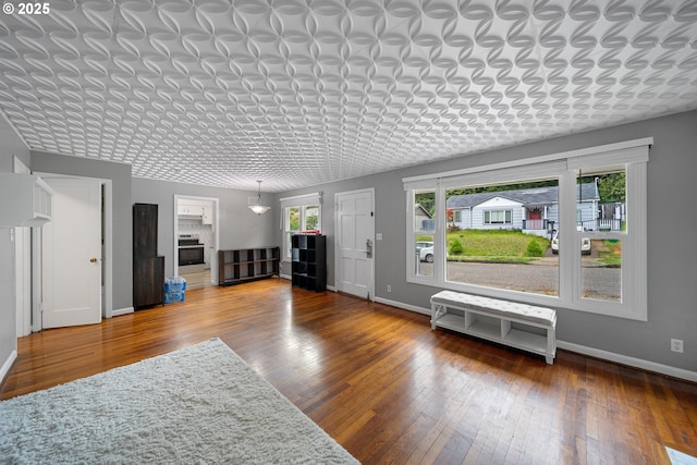 living room with healthy amount of natural light, baseboards, and hardwood / wood-style floors