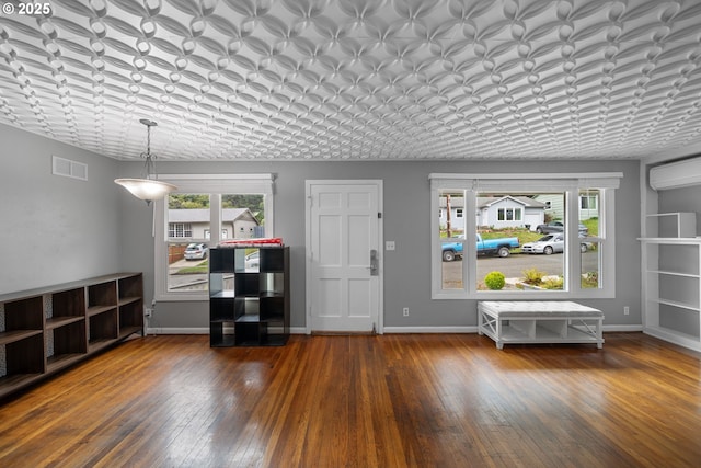 entrance foyer with healthy amount of natural light, wood-type flooring, and baseboards