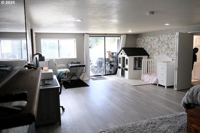bedroom featuring wood finished floors, multiple windows, a textured ceiling, a desk, and recessed lighting