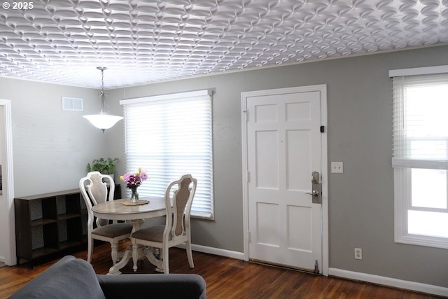 dining room with healthy amount of natural light, wood finished floors, and baseboards