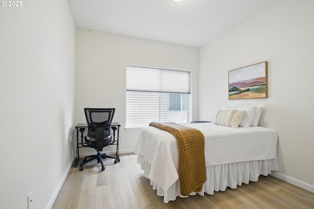bedroom with light wood-style floors and baseboards