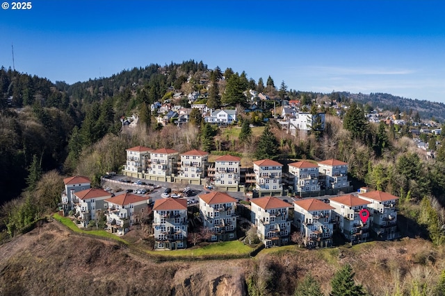 bird's eye view with a wooded view