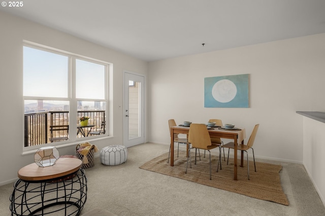 carpeted dining room featuring baseboards