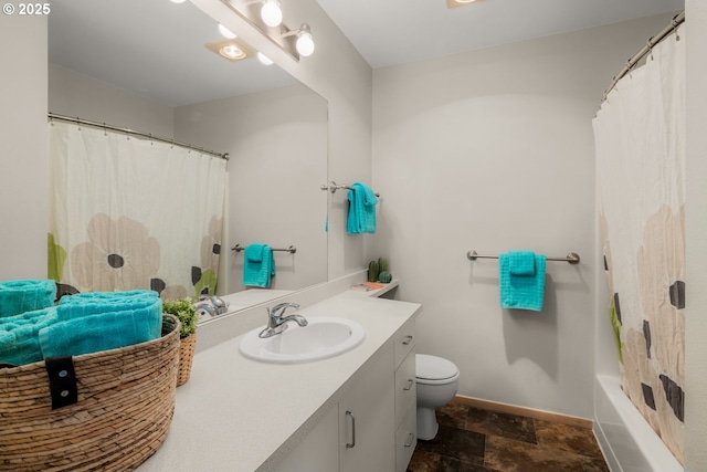 full bathroom with curtained shower, toilet, stone finish floor, vanity, and baseboards