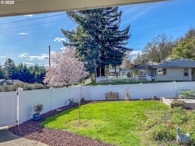 view of yard with a fenced backyard and a garden