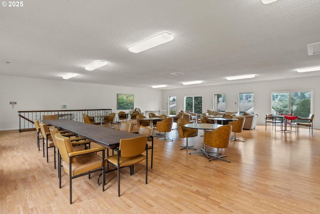 dining area with a textured ceiling and light wood-type flooring