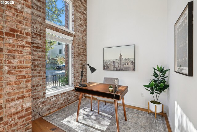 109 SW Gibbs St, Portland, OR 97239 - office space with brick wall, wood finished floors, baseboards, and a towering ceiling