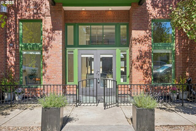 109 SW Gibbs St, Portland, OR 97239 - view of exterior entry with french doors, brick siding, and a porch