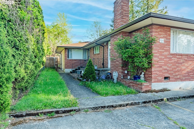 9023 SE Ankeny St, Portland, OR 97216 - view of home's exterior with a chimney, brick siding, and fence