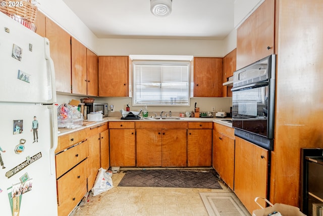 9023 SE Ankeny St, Portland, OR 97216 - kitchen featuring a sink, brown cabinetry, oven, light countertops, and freestanding refrigerator