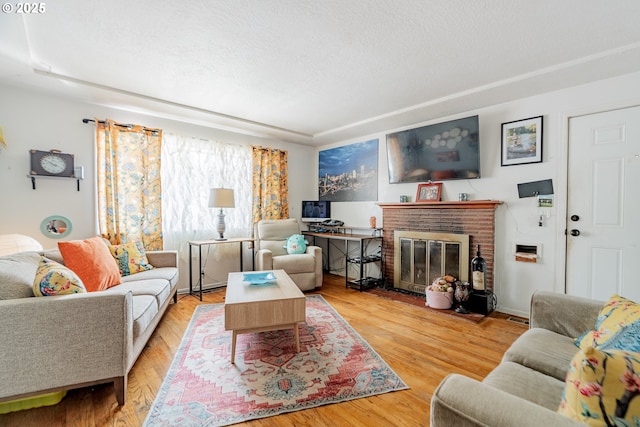 9023 SE Ankeny St, Portland, OR 97216 - living room with wood finished floors, a textured ceiling, and a brick fireplace