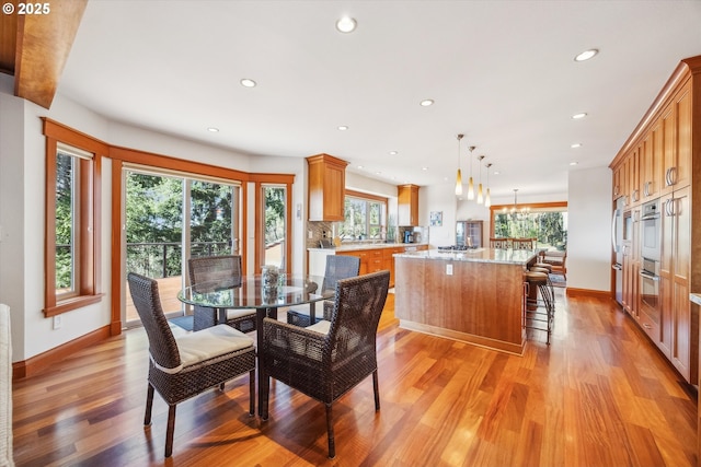 dining area featuring light hardwood / wood-style flooring, a chandelier, and a healthy amount of sunlight