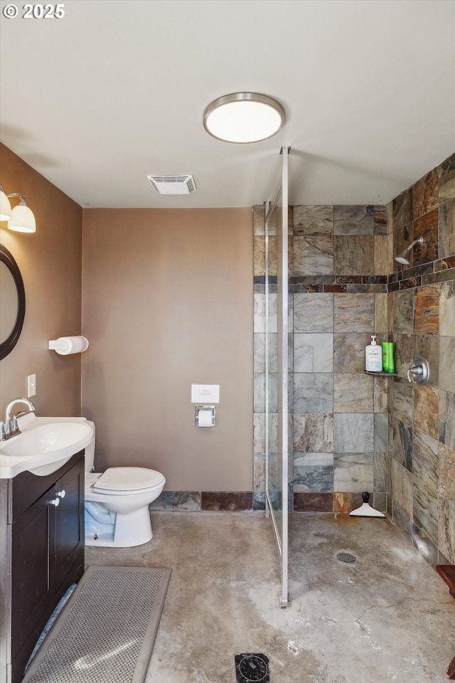 bathroom featuring vanity, concrete flooring, toilet, and a tile shower