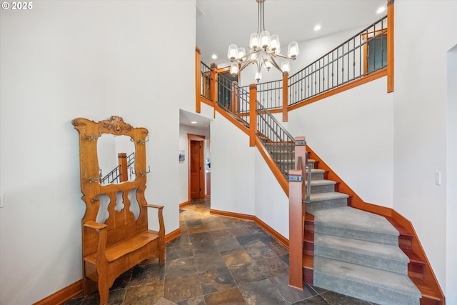 stairway with an inviting chandelier and a towering ceiling