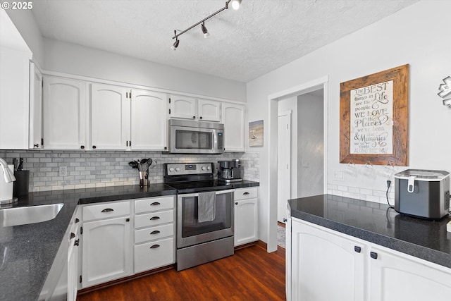 kitchen with white cabinetry, appliances with stainless steel finishes, and backsplash