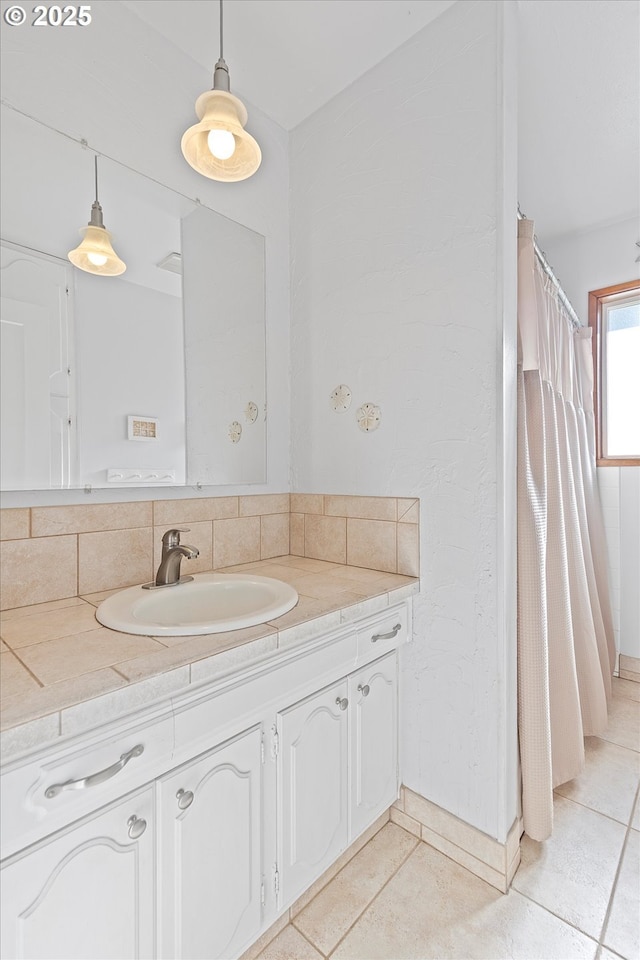 bathroom with tasteful backsplash, vanity, and tile patterned floors