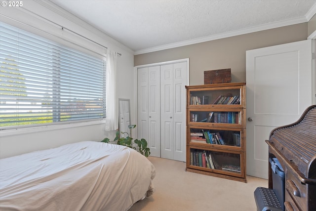 carpeted bedroom featuring ornamental molding, a closet, and a textured ceiling