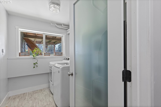 washroom with washer and dryer and light wood-type flooring