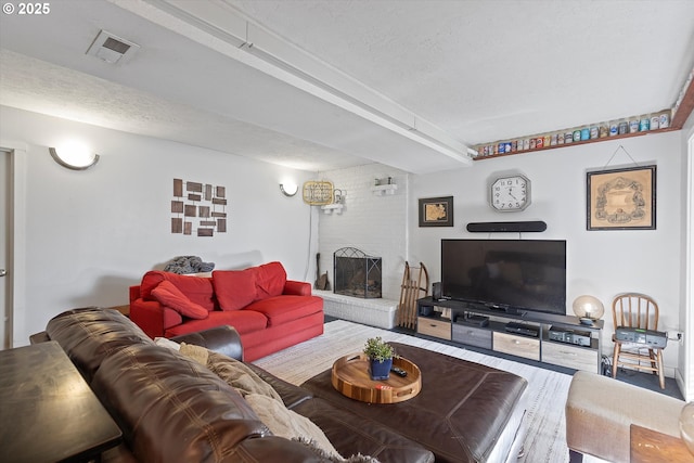 living room featuring a brick fireplace and a textured ceiling