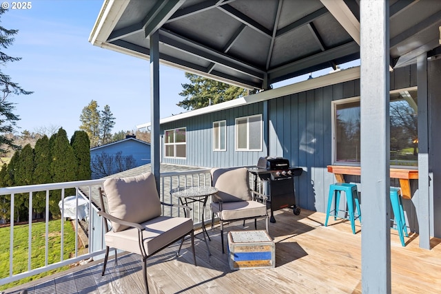 wooden deck with a bar and a grill