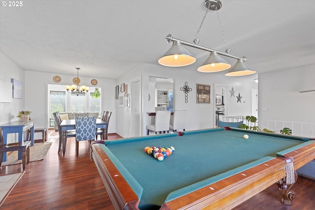 playroom with dark wood-type flooring, a textured ceiling, an inviting chandelier, and billiards