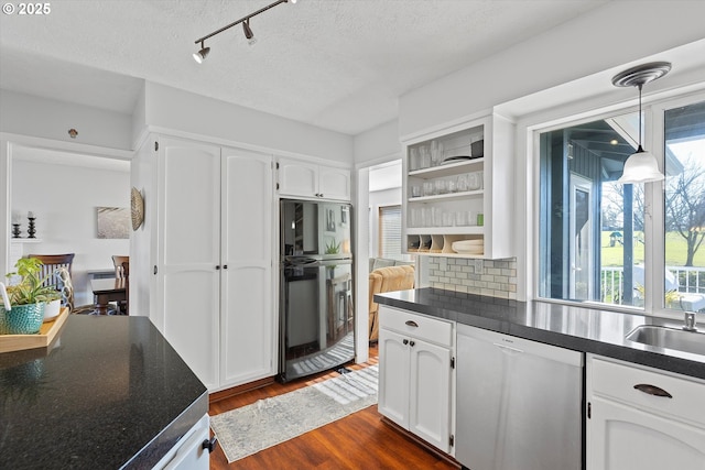 kitchen with decorative light fixtures, white cabinets, dark hardwood / wood-style flooring, dishwashing machine, and a textured ceiling