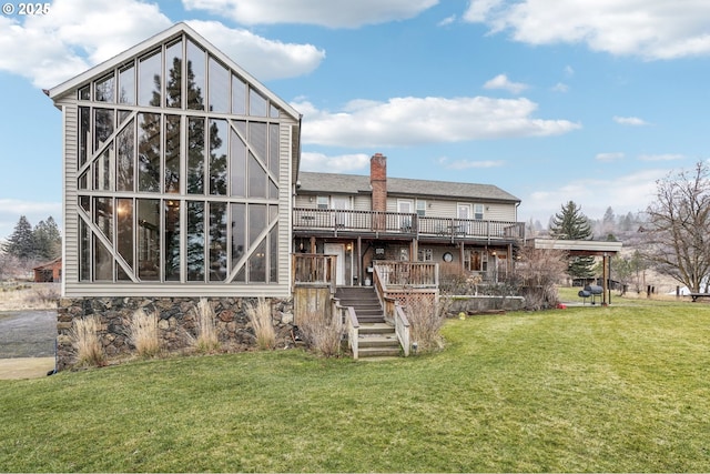 rear view of property with a deck and a yard