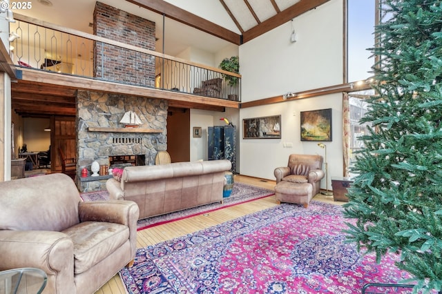 living room with a stone fireplace, high vaulted ceiling, plenty of natural light, and wood-type flooring