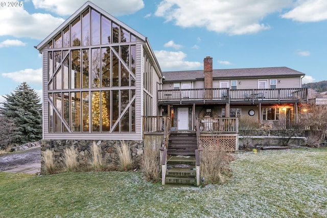 back of house featuring a lawn and a wooden deck