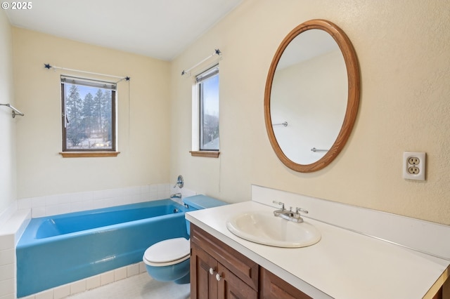 bathroom with toilet, vanity, and a tub to relax in