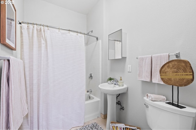 bathroom featuring shower / tub combo and toilet