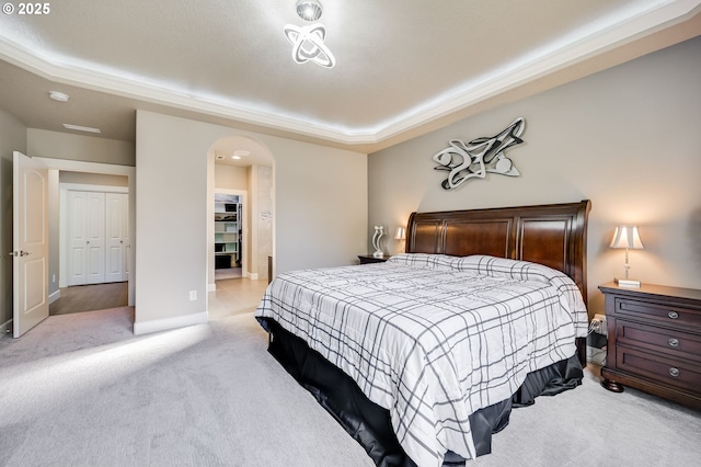 carpeted bedroom featuring a raised ceiling