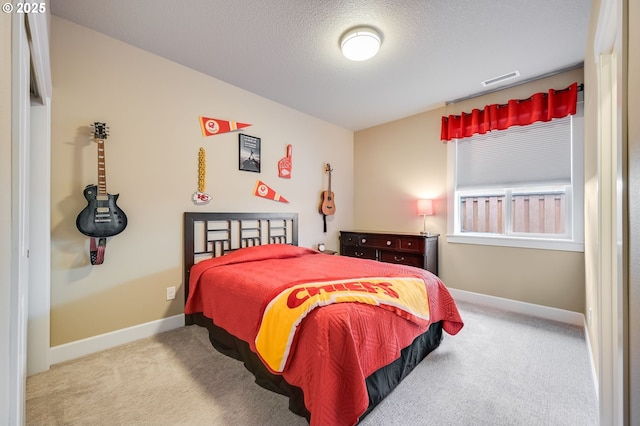 bedroom with a textured ceiling and light colored carpet