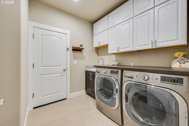 laundry room with light tile patterned floors, sink, washer and clothes dryer, and cabinets