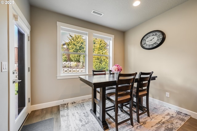 dining area featuring a textured ceiling and hardwood / wood-style flooring