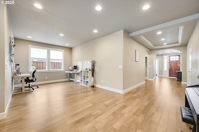 office space featuring light wood-type flooring and a textured ceiling