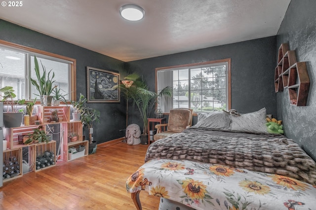 bedroom with wood finished floors and a textured wall