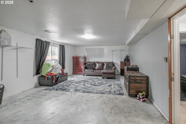 living room with unfinished concrete flooring and a textured ceiling