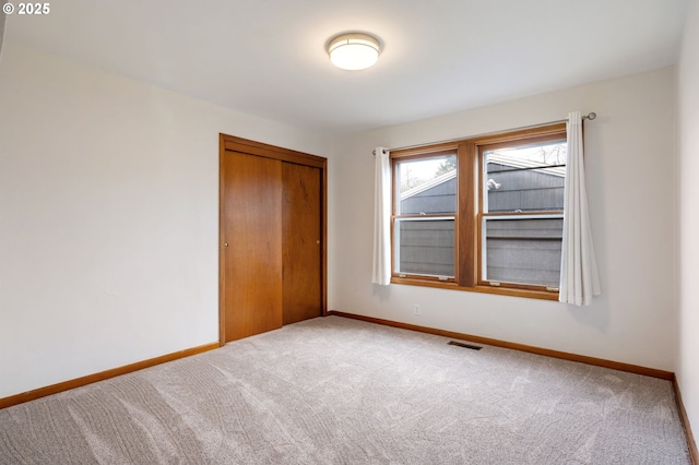 unfurnished bedroom with baseboards, visible vents, and a closet