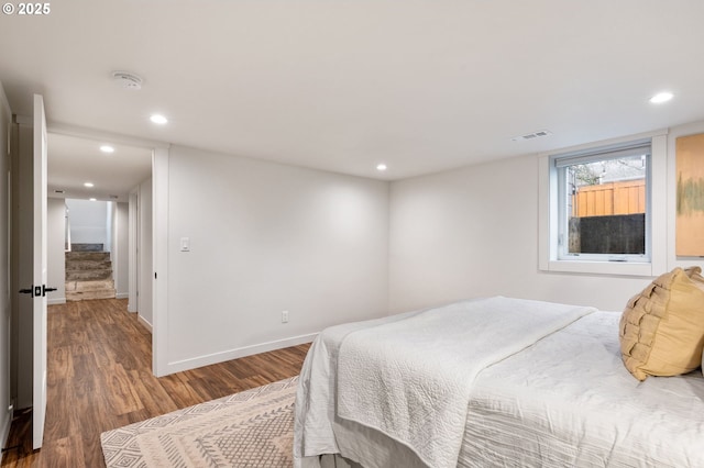 bedroom with recessed lighting, visible vents, baseboards, and wood finished floors