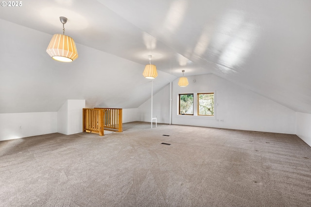 additional living space featuring light colored carpet and vaulted ceiling