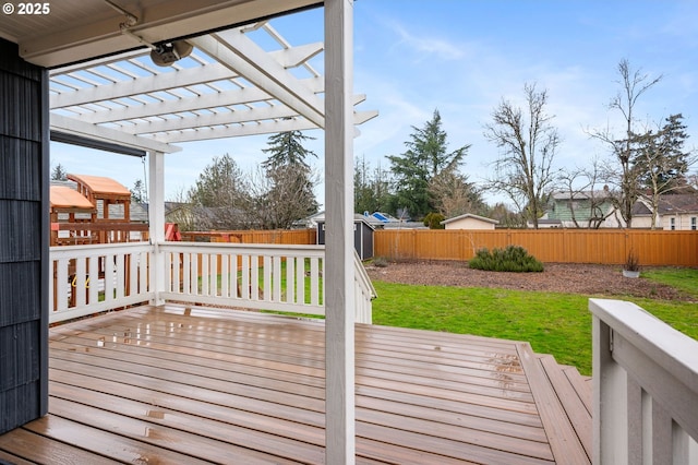 deck with an outbuilding, a yard, a storage shed, a pergola, and a fenced backyard