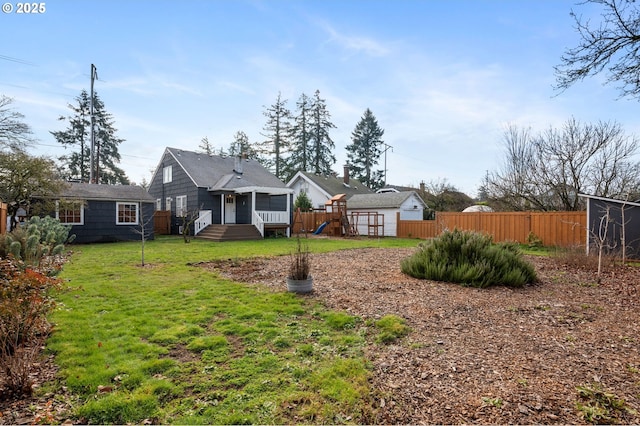 view of yard with a playground, fence, and an outdoor structure