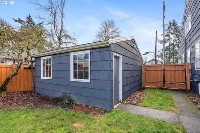 view of outbuilding featuring a gate, fence, and an outdoor structure