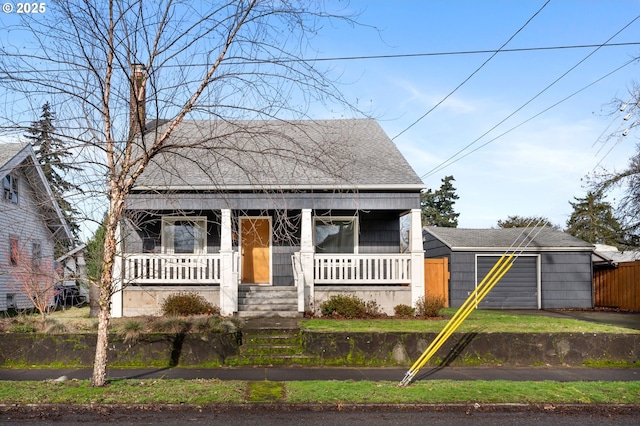 view of front of house featuring roof with shingles, a porch, and an outdoor structure