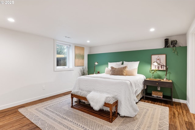bedroom featuring wood finished floors, recessed lighting, visible vents, and baseboards