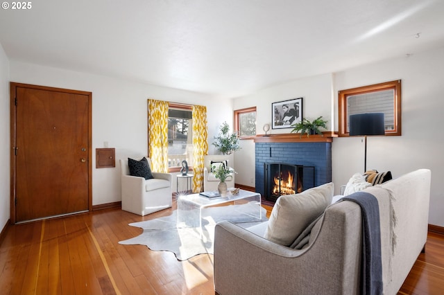 living room with baseboards, hardwood / wood-style flooring, and a fireplace