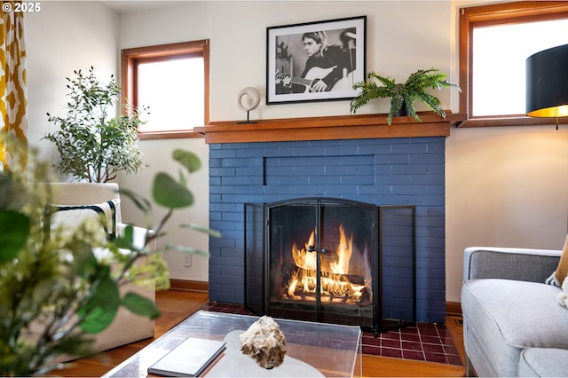 sitting room featuring a brick fireplace and baseboards